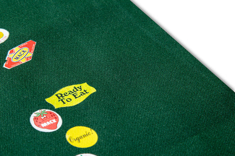 Green MACK tote bag featuring colorful fruit sticker design, casual carryall with sturdy handles and vibrant print.