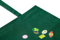 Green tote bag with vibrant fruit stickers by MACK, showcasing a casual, reusable accessory with colorful fruit designs.
