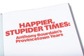 Close-up of the book cover for "Happier, Stupider Times" by Anthony Bourdain, featuring bold typography and vibrant design.