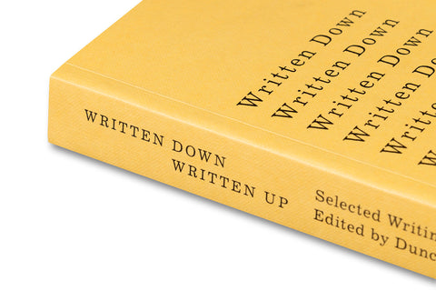 Close-up of the book cover for "Written Down / Written Up" by John Hilliard, published by MACK, showing textured design and title.